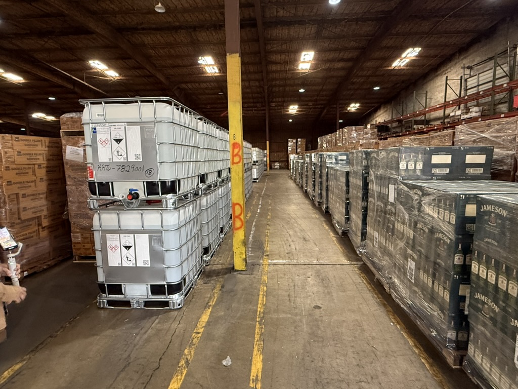 IBC hazmat totes and palletized spirits staged inside Carroll's Norfolk warehouse