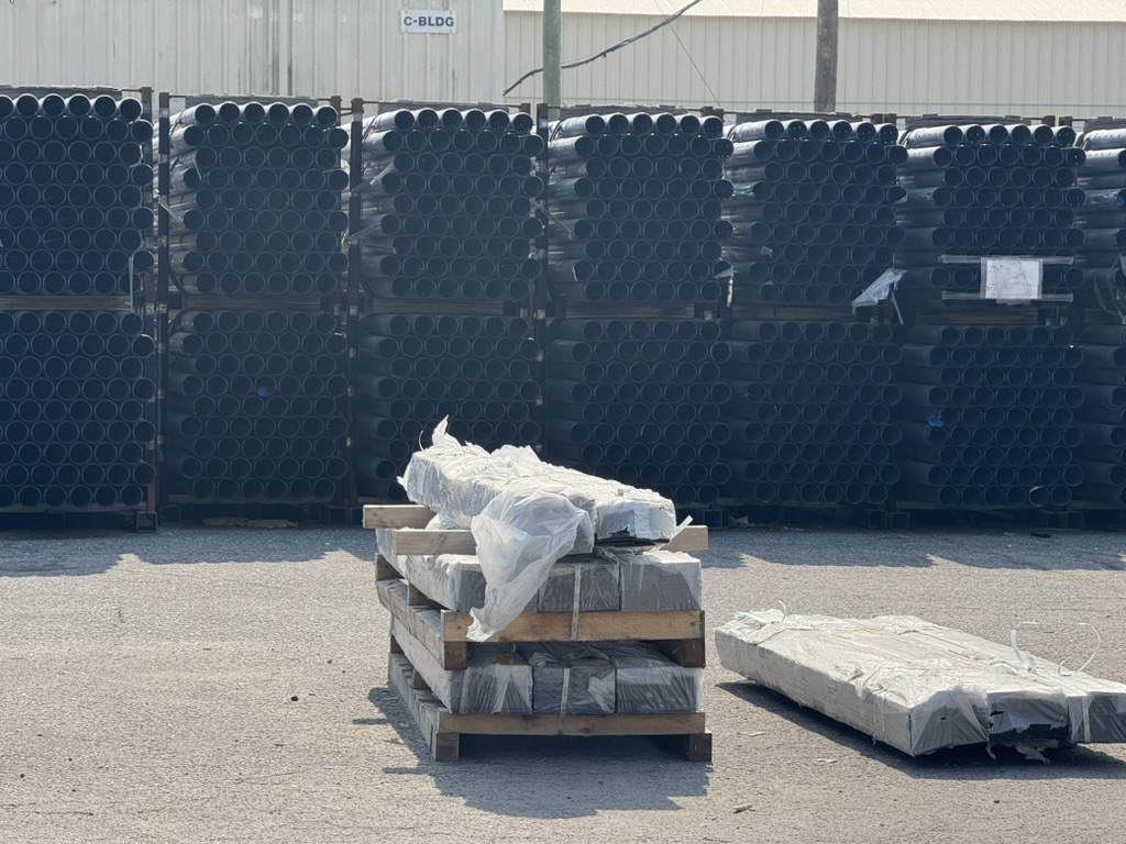 HDPE pipe bundles staged at Carroll's yard beside palletized stone